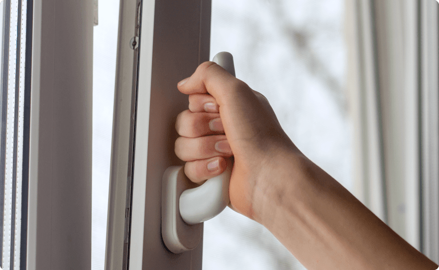 A Hand Holding a Handle to a Window