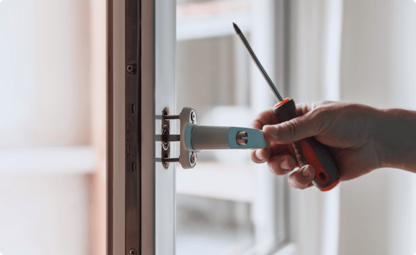 A Hand Holding a Screwdriver and Opening a Door